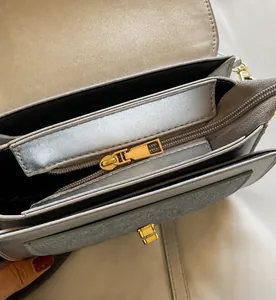 Detail view of denim saddle bag interior with golden metal zipper and compartments
