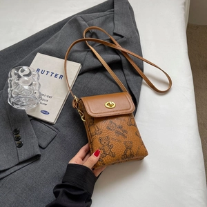 Detailansicht der braunen Ledertasche mit Bären-Print und goldenem Metall-Drehverschluss