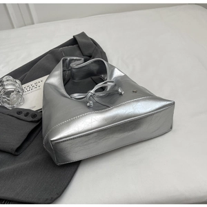 Detail of silver metallic hobo bag featuring crinkled texture and ribbon bow detail
