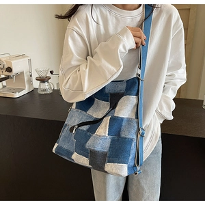 Detail of patchwork denim tote bag with adjustable canvas strap and front zipper pocket
