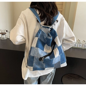 Detail of patchwork denim backpack with adjustable straps and vintage wash texture