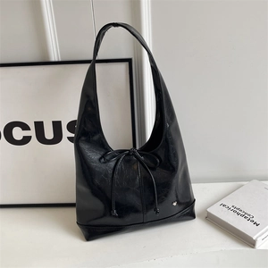 Minimalist black glossy hobo shoulder bag with silver heart charm and bow detail