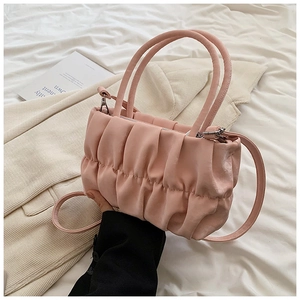 Detailed shot of pink pleated cloud bag with metallic zipper and detachable strap