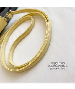 Detail of adjustable bright yellow faux leather shoulder strap with golden metal buckle