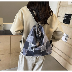 Detail of color-block denim patchwork backpack with wide shoulder strap and metal rings