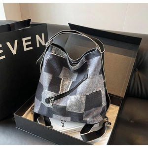 Detailed close-up of patchwork denim tote bag in a premium black gift box set