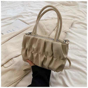 Detailed close-up of pleated beige cloud bag with zipper and detachable shoulder strap
