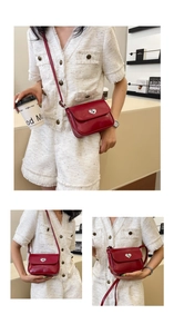 Detailed view of red leather crossbody bag featuring a silver heart-shaped metal buckle