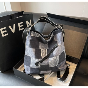 Detail of checkered denim patchwork tote bag with wide strap in a premium gift box