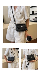 Detail of a black glossy leather shoulder bag featuring a silver heart-shaped metal lock
