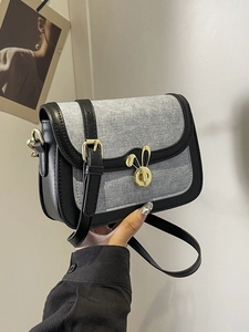 Vintage denim saddle bag with black leather trim and gold rabbit twist lock buckle