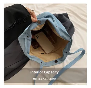 Detail of the blue denim tote bag interior showing the large capacity and zipper pocket