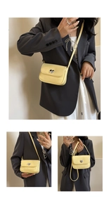 Detail of yellow crossbody bag featuring a silver heart-shaped lock and shiny PU texture