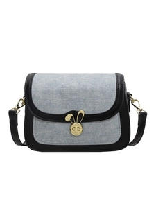 Denim saddle crossbody bag with black leather trim and gold rabbit ear twist lock