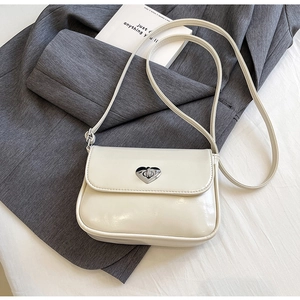 Close-up of minimalist cream white square crossbody bag with silver heart-shaped metal lock