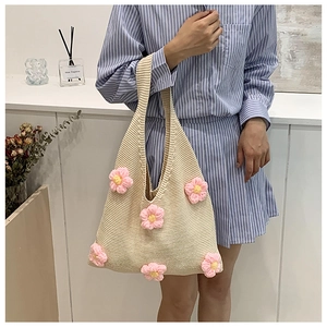 Détail du sac cabas au crochet avec fleurs roses 3D sur tissu tricoté beige