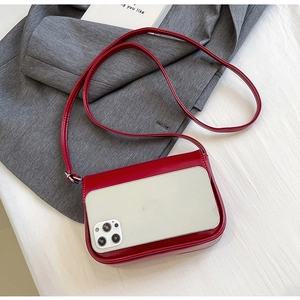 Red leather crossbody phone bag shown with a smartphone to demonstrate compact capacity