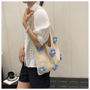 Détails de ce sac fourre-tout en tricot beige avec des fleurs bleues et jaunes à la main