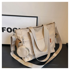 Detail view of canvas tote bag with adjustable straps and detachable coin purse accessory