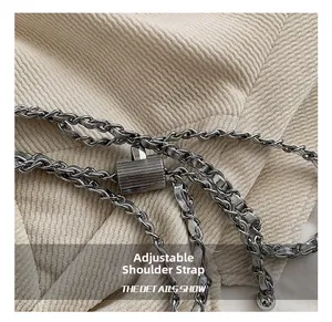 Detail of silver chain strap with adjustable cylindrical metal buckle on beige fabric