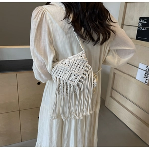Detail of white bohemian woven shoulder bag featuring long fringe and geometric patterns