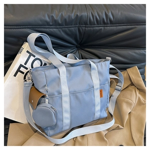Detail of light blue nylon tote bag with brown leather pocket and round coin purse