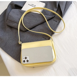 Mini yellow crossbody bag with phone size comparison on a grey blazer and white background