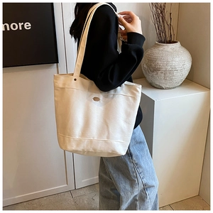 Casual large capacity denim canvas tote bag worn on shoulder for daily commute