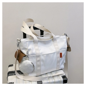 Detail of off-white canvas tote bag with brown side pocket and mini round coin purse