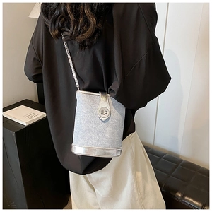 Detail of silver glitter bucket bag with metal chain strap and sleek metallic base trim