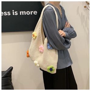 Détail d'un grand sac cabas en maille crème avec des fleurs colorées tricotées en 3D