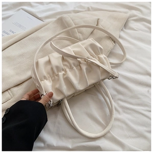 Detail of off-white pleated dumpling bag with soft PU leather texture and shoulder strap