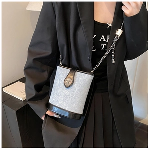 Mini bucket bag featuring light blue fabric and black leather details on a female model