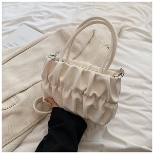 Detail of cream pleated cloud handbag with silver hardware and adjustable shoulder strap