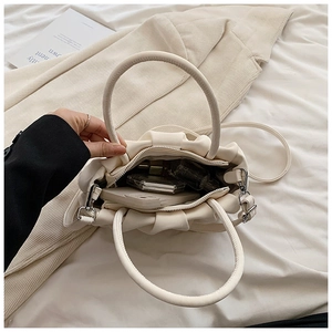 Top-down view of the cream pleated bag interior showing spacious storage space