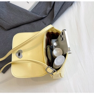 Internal view of the yellow crossbody bag showing storage capacity for phone and cosmetics