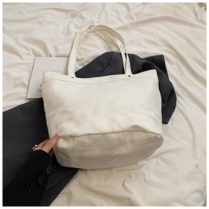 Detail of the reinforced stitching and soft fabric texture on this white canvas tote bag