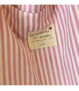 Close-up of the woven label and pink striped texture on a canvas tote bag