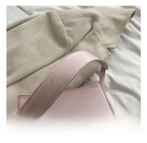 Détail du sac à main rose pâle avec poignée large et texture soyeuse raffinée