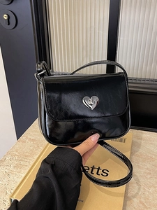 Chic black patent leather crossbody bag with a silver heart-shaped twist lock buckle