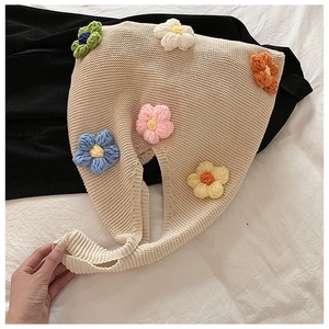 Détail de fleurs au crochet sur un sac à bandoulière en tricot beige doux