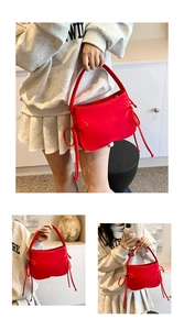 Détail du sac rouge avec de longs nœuds à pompons et une texture en nylon lisse