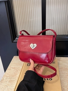 Red leather shoulder bag with a silver heart-shaped twist lock for stylish daily commute