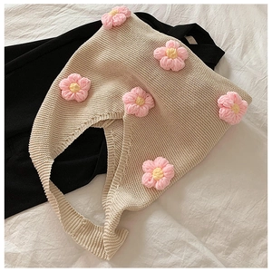 Détail de motifs floraux tricotés main sur un sac au crochet beige à fleurs roses 3D