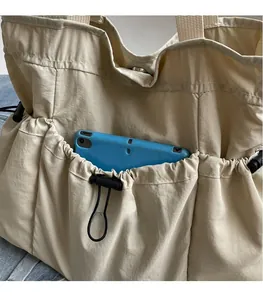 Detail einer beige Tragetasche mit Seitenfach-Stauraum für elektronische Geräte