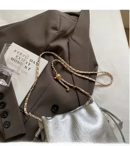Close-up of silver chain bucket bag featuring metallic texture and adjustable ball buckle