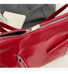 Detailed macro view of silver metallic smooth zipper on red glossy PU leather bag