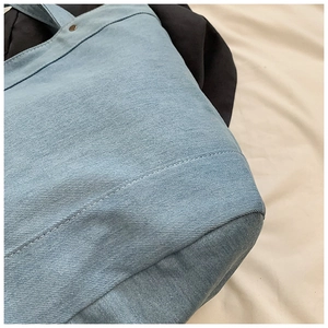 Detailed view of light blue denim tote bag with reinforced stitching and soft fabric texture