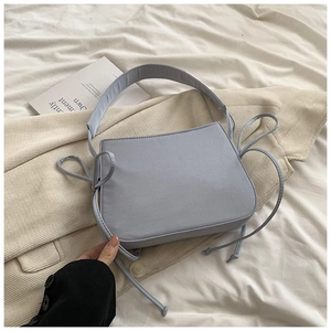 Vue détaillée du sac bandoulière élégant en tissu bleu clair avec cordon sur un drap blanc