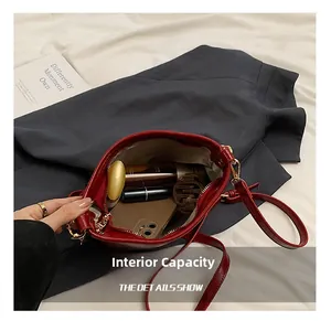 Macro view of red leather crossbody bag showing interior capacity with phone and lipstick